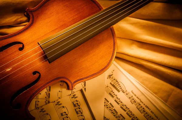 旧小提琴躺在乐谱上，音乐的概念 — 图库照片