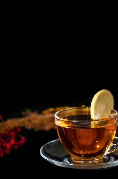 Té en taza con limón sobre fondo negro — Foto de Stock