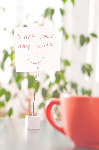 Nota sobre la mesa empezar el día con sonrisa — Foto de Stock