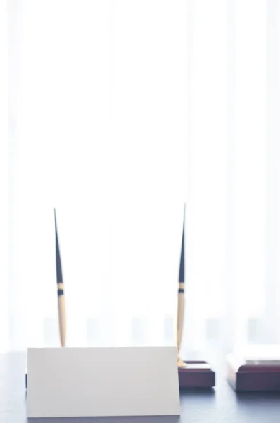 Weißes dreieckiges Schild für das Etikett, das auf einem schwarzen Tisch steht. — Stockfoto