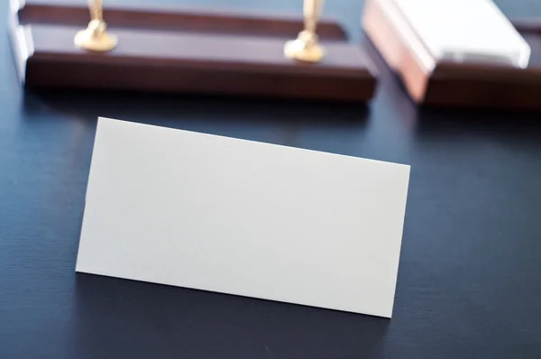 Weißes dreieckiges Schild für das Etikett, das auf einem schwarzen Tisch steht. — Stockfoto