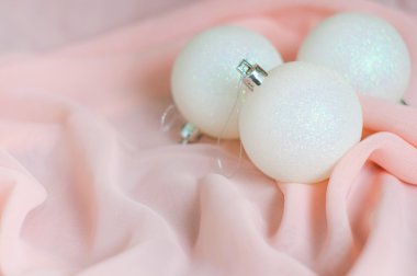 Pembe bir arka plan üzerinde beyaz yeni yıl ve Noel topları