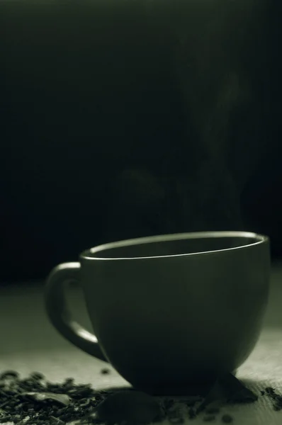 干与绿茶叶在杯子里，在粗麻布背景 — 图库照片