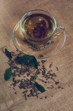 Kuru çay Kupası, çuval bezi zemin üzerine yeşil yaprakları ile