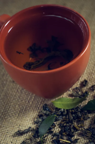 Taza de té verde con pastel sobre fondo de arpillera —  Fotos de Stock