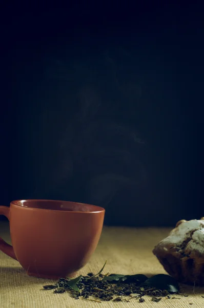 Чашка зеленого чаю з тортами на тлі мішковини — стокове фото