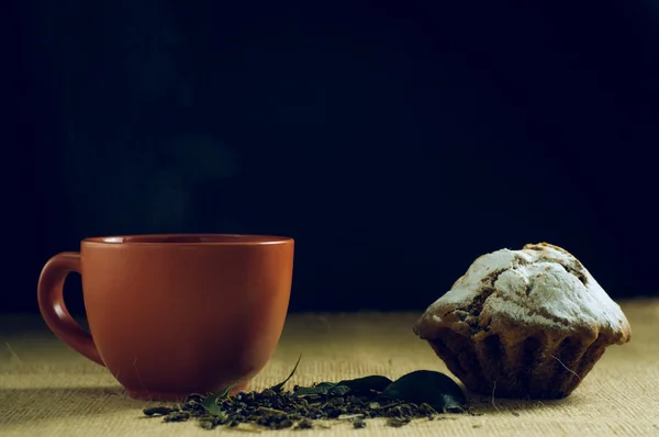 Cup of green tea with cake on burlap background — Stock Photo, Image