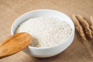 pirinç tahıl ve tahta kaşık çuval bezi arka plan üzerinde