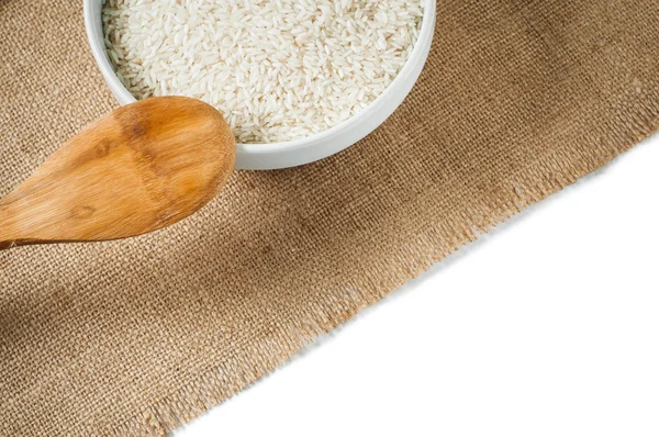 Rice cereal and wooden spoon on burlap background. isolate — Stock Photo, Image