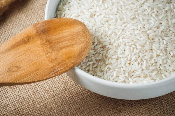 Rice cereal and wooden spoon on burlap background — Stock Photo, Image