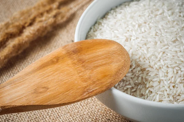 Rice cereal and wooden spoon on burlap background — Stock Photo, Image