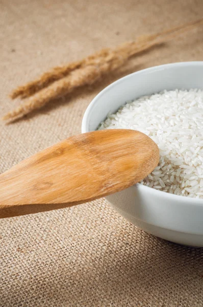 Rice cereal and wooden spoon on burlap background — Stock Photo, Image