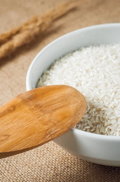 Rice cereal and wooden spoon on burlap background — Stock Photo, Image