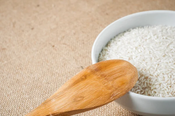 Rice cereal and wooden spoon on burlap background — Stock Photo, Image