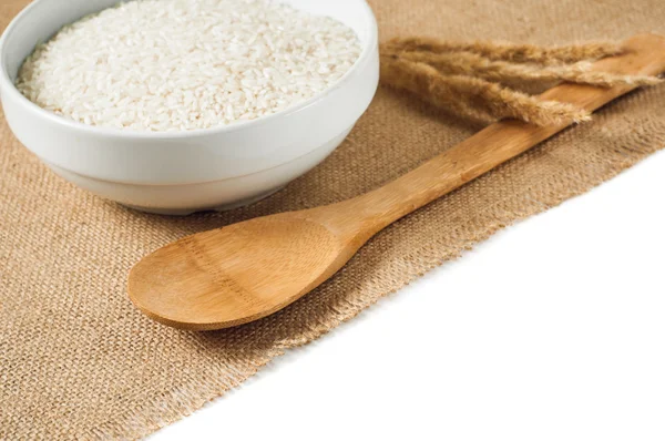 Rice cereal and wooden spoon on burlap background. isolate — Stock Photo, Image