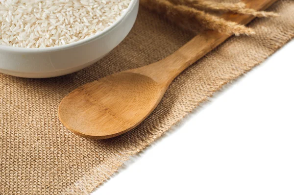 Rice cereal and wooden spoon on burlap background. isolate — Stock Photo, Image