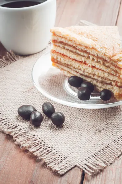 Café, gâteau et cacahuètes sur le fond en bois — Photo