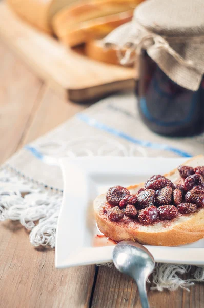 Mermelada de fresa, pan en el fondo de la mesa — Foto de Stock