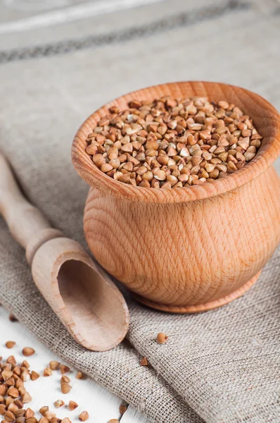 Buckwheat in a wooden bowl on white background — Stock Photo, Image