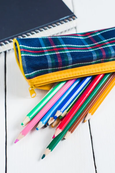 Schetsboek en kleurrijke potloden op tafel. — Stockfoto