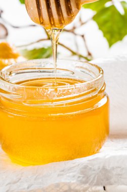 Kepçe ve akan, limon tahta arka plan ile bal kavanozu