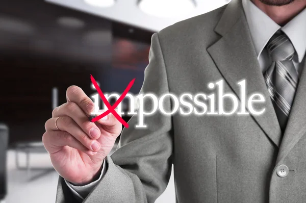 Uomo d'affari Mano trasformando la parola Impossibile in possibile con marcatore rosso — Foto Stock