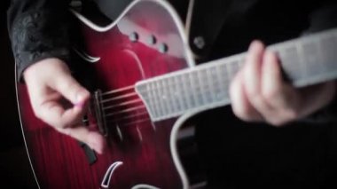 Adam akustik gitar çalıyor.