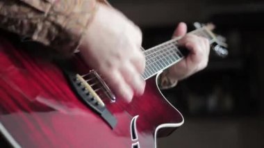 Adam akustik gitar çalıyor.