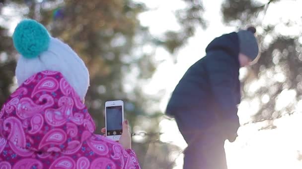 Madre toma una foto de su hijo en el bosque de invierno — Vídeos de Stock