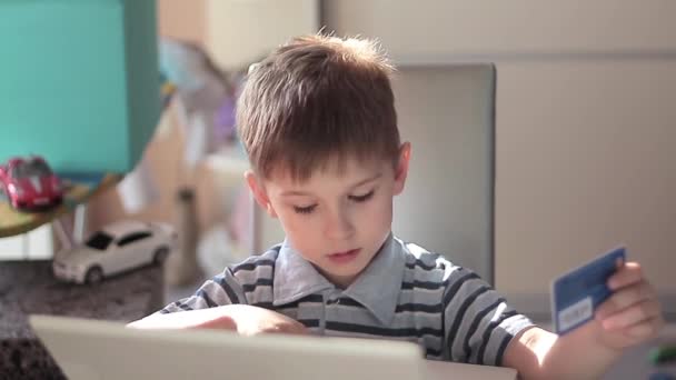 Cute little boy use laptop and credit card — Stock Video