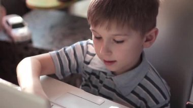 Sevimli küçük çocuk kullanmak laptop ve kredi kartı