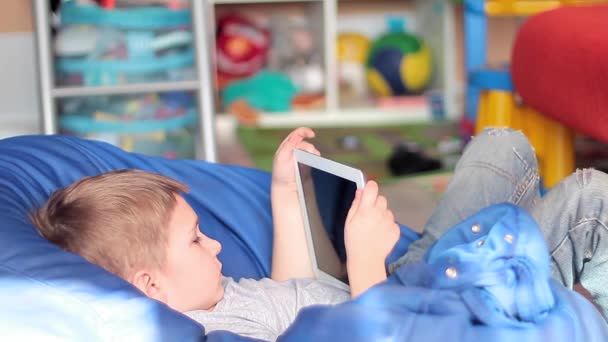 Malý chlapec hraje na tabletu počítačové hry — Stock video