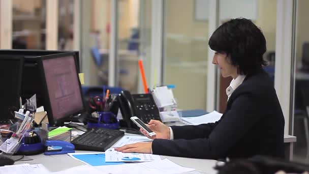 Businesswoman in office with computer and smartphone — Stock Video