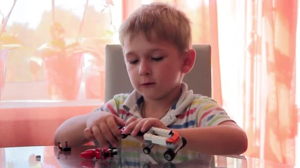 Boy design machine from colored toy pieces — Stock Video