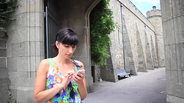 Junge Frau benutzt Smartphone in der antiken Stadt — Stockvideo