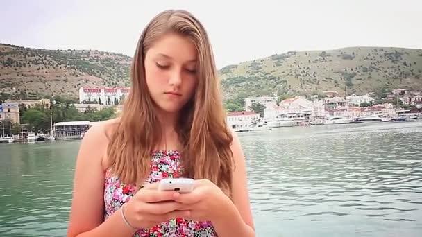 Dívka použijte smartphone na pozadí moře — Stock video