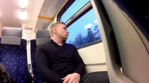 Мужчина смотрит в окно поезда — стоковое видео