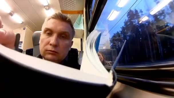 男人在一辆客运火车读的书 — 图库视频影像