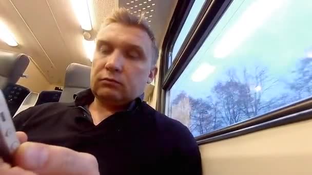 L'homme utilise un smartphone dans un compartiment d'un train de voyageurs — Video