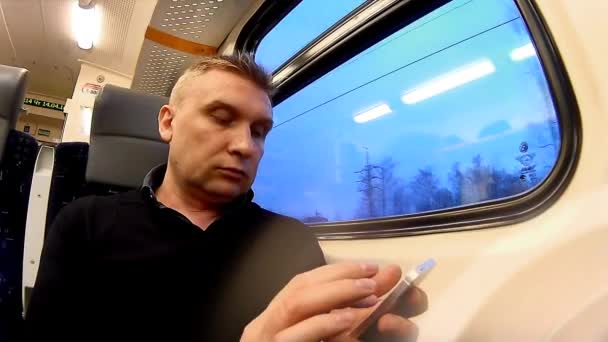Чоловік використовує смартфон у відсіку пасажирського поїзда — стокове відео