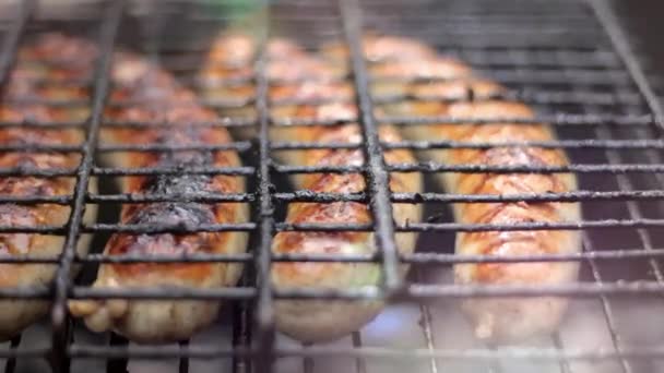 Salchichas Bratwurst cocinando en una barbacoa de madera . — Vídeo de stock