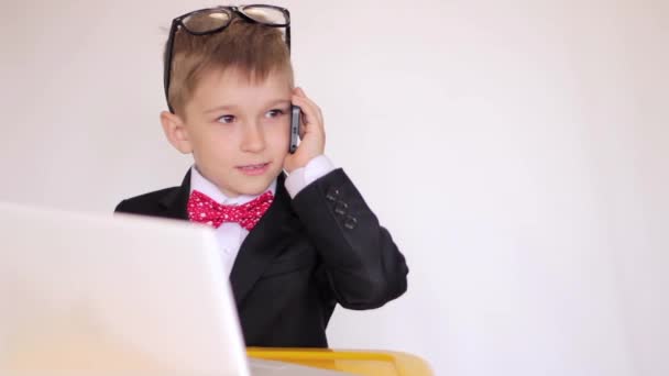 Lindo chico jugando a ser hombre de negocios, concentrado en el trabajo, hablando por teléfono. Éxito — Vídeo de stock