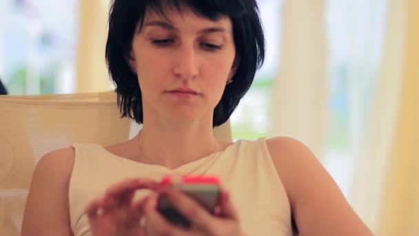 Jonge vrouw met smartphone in café — Stockvideo