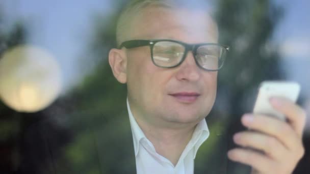 Człowiek na café za pomocą inteligentnego telefonu aplikacji tekstowych wiadomości sms picia kawy — Wideo stockowe