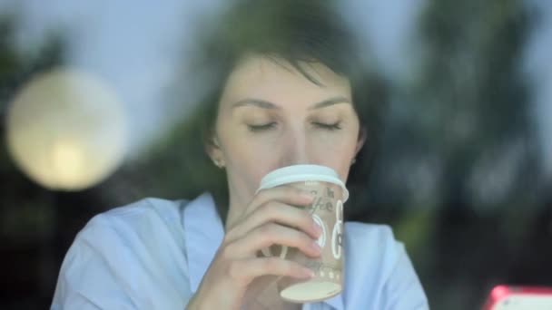 Mujer usando la aplicación en el teléfono inteligente en la cafetería bebiendo café sonriendo y mensajes de texto en el teléfono móvil. Hermosa joven multicultural casual profesional femenino en el teléfono móvil . — Vídeos de Stock