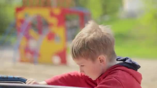 Jongen op merry-go-round in park. Carrousel — Stockvideo