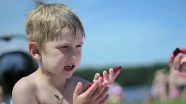 Sahilde küçük bir çocuk yemek istemiyor. Çocuk aç değil
