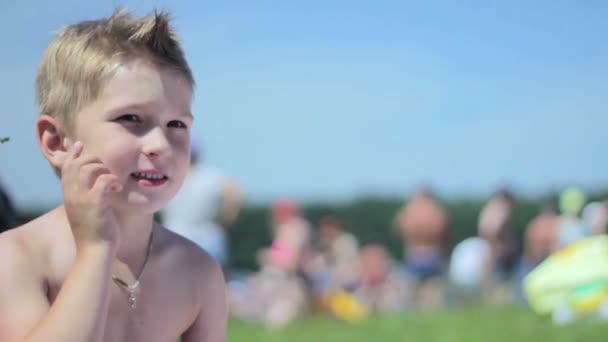 Portrait un petit garçon heureux sur la plage . — Video