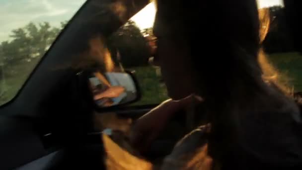 Άνεμος φυσά μέσω κορίτσια σιλουέτα και μαλλιά σε ένα αυτοκίνητο. Ηλιοβασίλεμα — Αρχείο Βίντεο