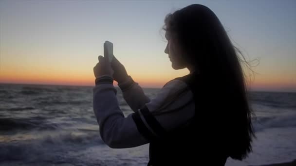 Chica tomando fotos en la playa. Disparo de mano — Vídeos de Stock